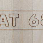 Letters "LAT68.com" laser engraved on wood