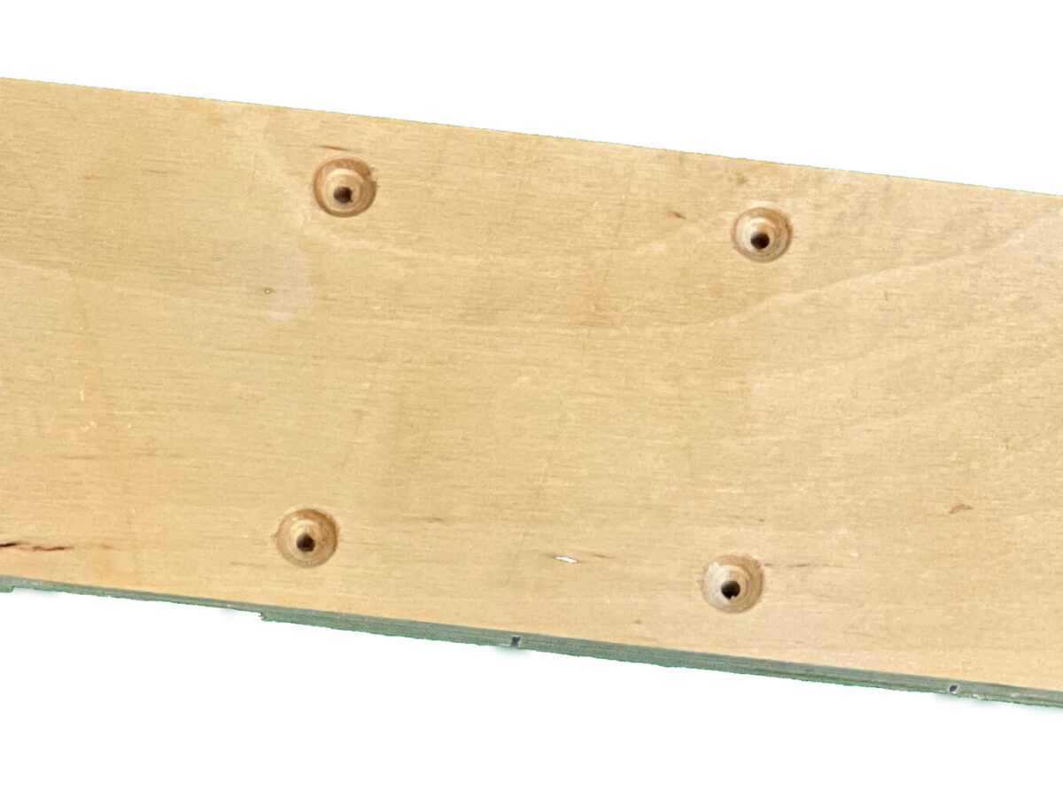 Plywood platform with eight pre-drilled holes for screws; to be mounted on a ski.