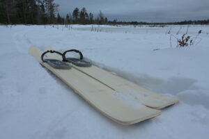 Pair of skis on snow near frozen lake