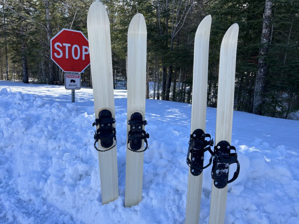 Two pairs of LAT68 back country skis with danger bears sign on background.