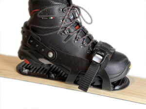 A boot inside two strap binding mounted on a ski.